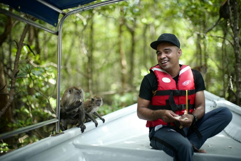 A cheerful encounter with monkeys in Langkawi's lush jungle from a boat adventure.